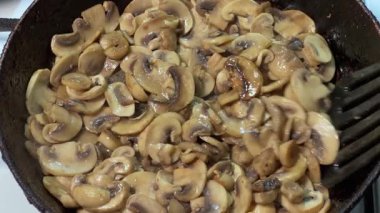 Kızartma sırasında kızartılmış tavada kızartılmış düğme mantarları.