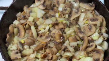 Kızartma sırasında tavada soğanlı tuzlu mantar.
