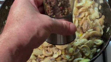 Kızartma sırasında tavada soğanlı biberli mantar.