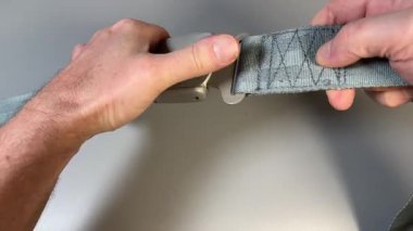 Gri arka planda emniyet kemeri açılırken