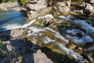 Sonbahar güneşli bir günde, bir dağ nehrinde çok katmanlı şelale şelalesi.