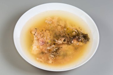 Gri arka planda beyaz kasede sazan balığından yapılmış jöleli balık.