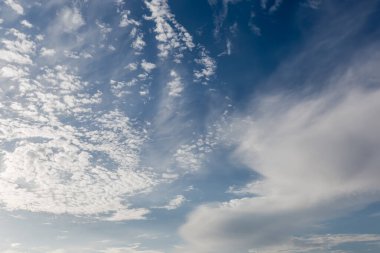 Section of the blue sky with stratocumulus floccus and cirrus clouds at summer sunny day clipart