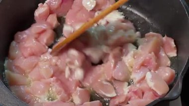 Tahta spatulayla karıştırılırken tavuklu kızartma tavuğu.