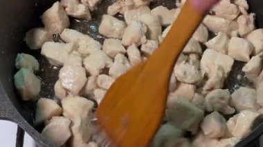 Tahta spatulayla karıştırılırken tavuklu kızartma tavuğu.