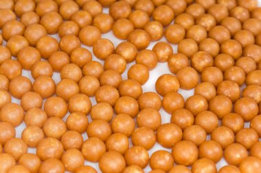 Beyaz bir tabak üzerinde bal ve diğer arıcılık ürünlerinden yapılmış şekerlemeler, seçici odak noktasında yakın plan