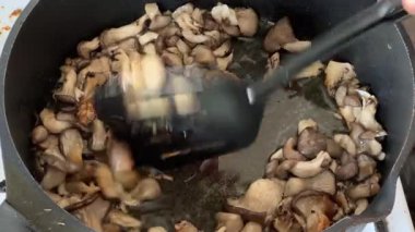 Kızartma sırasında spatula, istiridye mantarı ve kızartma tavasıyla karıştırılıyor.
