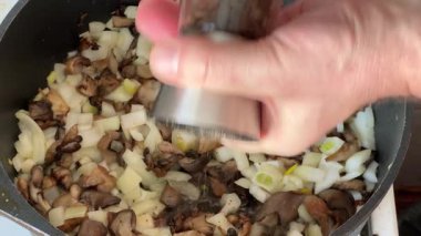 Kızartma tavasında istiridye mantarlarına karabiber ekliyorum.