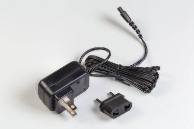 Amerikan AC 'si iki uçlu fişi olan ve gri arka planda Euro prizine ayrı adapte olan çeşitli cihazlar için güç ünitesi.