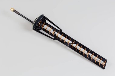 Gri arka planda eşeksen kablosunun ucunda eşeksen konnektörü olan yüksek frekanslı mobil elektronik birimin küçük boyutlu sarmal anteni