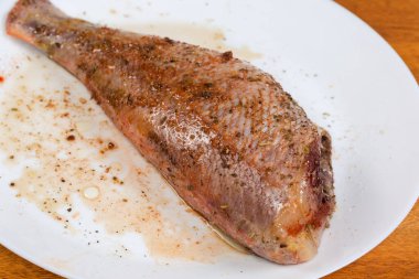 Çiğ yağda eritilmiş leş, kırmızı balık başı olmadan, okyanus levreği olarak da bilinir, baharatlarla marine edilmiş, yemek pişirilmeden önce, seçici bir odak noktasında.