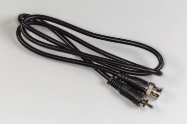 Gri bir yüzeyin kenarlarında gümüş konnektörlü BNC ve RCA ile yüksek frekanslı eş eksenli video kablo adaptörü