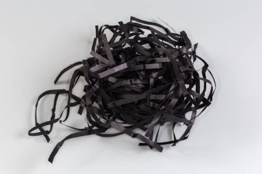 Gri arkaplandaki siyah kağıt şeritleri şeklinde yumuşak ambalaj malzemesi.