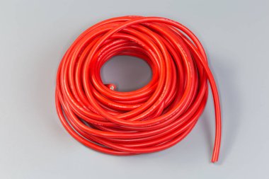 Kırmızı yalıtımlı kırmızı silikon kabloyla sarılı tek çekirdek elektrik kablosu. Uygulamalı kesit ve ısıya dayanıklı işaretler gri arka planda yatıyor.