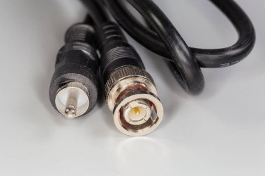 Gri bir yüzey üzerinde yüksek frekanslı video kablo adaptörünün kenarlarında BNC ve RCA türleri elektrik eşeksenli gümüşü tıkaçları