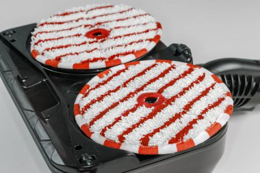Sert zeminin ıslak temizlenmesi için yer değiştirilebilir elektrik süpürgesinin alt kısmındaki yuvarlak mikrofiber paspaslar, seçici odak noktasında yakın çekim