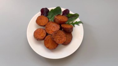 Pişmiş tatlı patates yumrusu tabakta daireler halinde dilimlenmiş.
