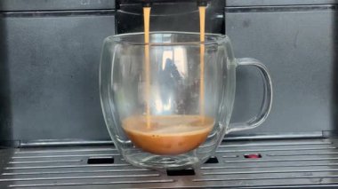 Cam bardakta otomatik kahve makinesiyle demlenmiş kahve.