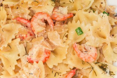 Kelebek şeklinde pişirilmiş makarna, sözde farfalle, kaynamış karides kuyruklu, yakın plan.