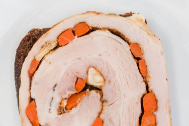 Fırında domuz eti dilimli sandviç. Kahverengi ekmekli sebzeli sandviç. Beyaz bir tabakta.