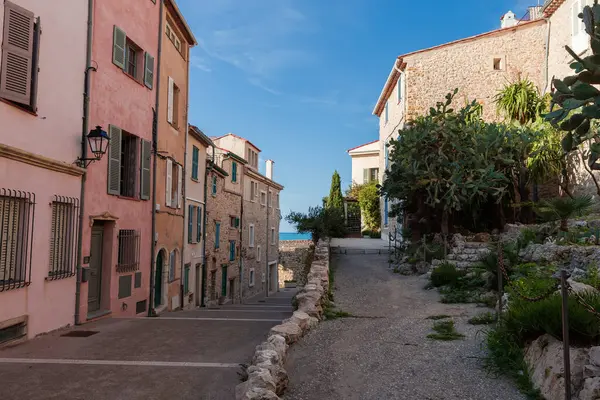 Eski şehrin bir tarafında sulu bitkilerle dekore edilmiş üç katlı taştan binalarla deniz yamaçlı yaya caddesi, sonbahar güneşli günleri manzaralı.