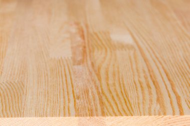 Bireysel açık renkli çam ağacından yapılmış düz tahta panelin ucu birbirine yapışmış, tahtanın sonundan seçici bir odak noktasında yakın plan görüntüsü