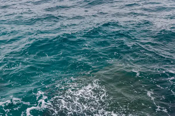 Sonbahar yağmurlu bir havada, açık deniz dalgalanmalarında, deniz kıyısının su yüzeyinde.