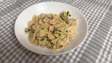 Kelebek şeklinde fırında makarna ve haşlanmış karides kuyruğu.