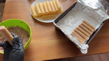 Pişirmek için et dolması yaparken çiğ cannelloni makarna.