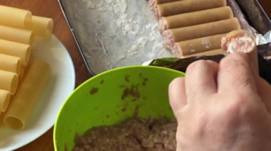 Pişirmek için et dolması yaparken çiğ cannelloni makarna.