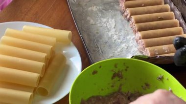 Pişirmek için et dolması yaparken çiğ cannelloni makarna.