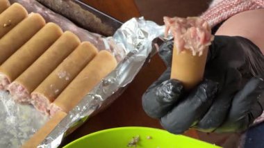Pişirmek için et dolması yaparken çiğ cannelloni makarna.