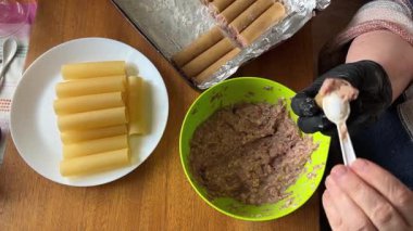 Pişirmek için et dolması yaparken çiğ cannelloni makarna.