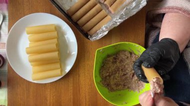 Pişirmek için et dolması yaparken çiğ cannelloni makarna.
