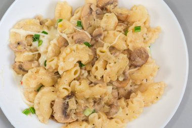 Creste di gallo olarak adlandırılan, taze pişmiş kısa kıvrımlı makarna, ya da mantarlı horoz tarağı ve bir tabakta beyaz souse peyniri, yakın çekim