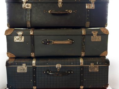 Kapalı, dikdörtgen şeklindeki, eski moda, eski püskü, kabuklu bavullar, beyaz bir arka planda deri deriyle yapılmış.