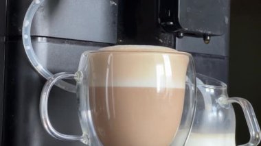 Kahve makinesiyle hazırlanmış cam bardakta kapuçino.