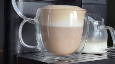 Kahve makinesiyle hazırlanmış cam bardakta kapuçino.