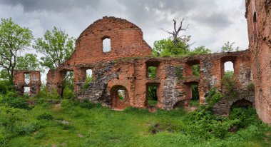 Eski savunma duvarının bir parçası ve harap olmuş ortaçağ şatosunda, avlu tarafından panoramik manzaralı, kayadan ve kırmızı tuğladan yapılmış diğer yapılar.