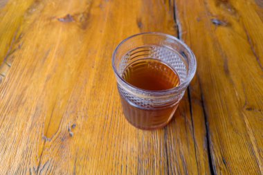 Ukrayna mutfağında eski bir meşe ağacının üzerindeki bardakta Uzvar olarak bilinen kurutulmuş meyve ve dutlardan yapılan soğuk tatlı içecek seçici bir odak noktasında.