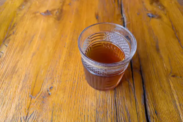 Ukrayna mutfağında eski bir meşe ağacının üzerindeki bardakta Uzvar olarak bilinen kurutulmuş meyve ve dutlardan yapılan soğuk tatlı içecek seçici bir odak noktasında.