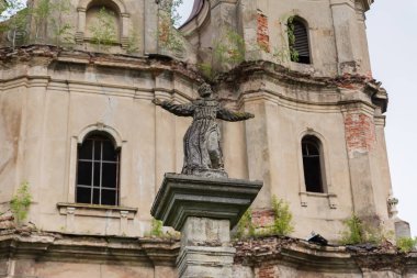 18. yüzyılda Ukrayna 'nın başkenti Hvizdets' teki bulutlu bir günde St. Anthony Kilisesi 'nin ön cephesinin bulanık arka planında Dukla' nın Aziz John heykelinin bulunduğu mimari sütun.