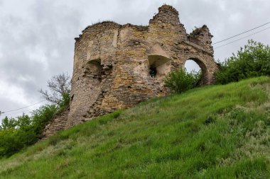 17. yüzyılın Sydoriv Şatosu 'nun güney taş kulesi. Ukrayna' nın Sydoriv köyündeki tepede giriş ve payandaları var. Yağmurlu bir günde tepenin eteklerinden manzara.