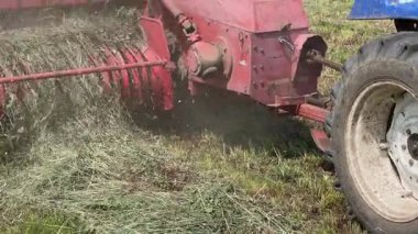 Bir tarlada küçük kare balyalarla saman balyalamak