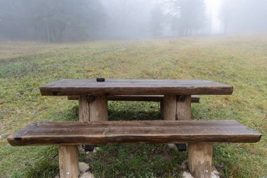 Kahverengi, ahşap bir masa, sonbaharda sislerin içinde.