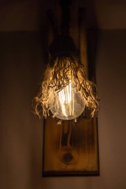 Öndeki cam şeffaf lamba bornoz dekorlu klasik top şekli ahşap duvarda.