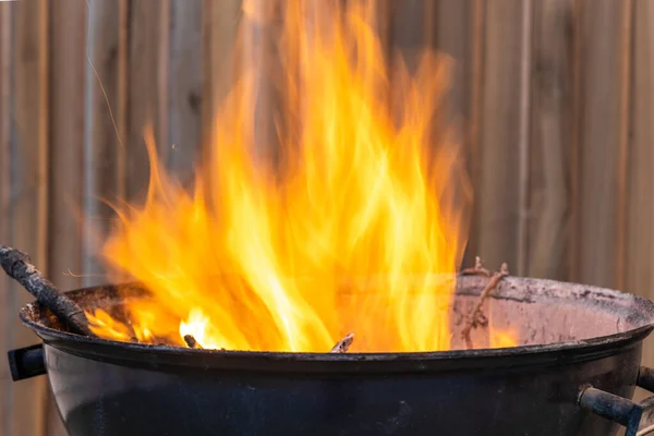 stock image The Black metal round barbeque with fire for a picnic is in the terrace