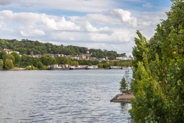 Güzel bir manzara. Yazın eski tekneleri ve yeşil ağaçları olan bir nehir.