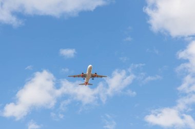 Paris, Fransa - 07 07 07 2023: Şaseli beyaz ve kırmızı uçak bulutlu mavi bir gökyüzüne iniyor