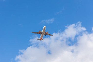 Paris, Fransa - 07 07 07 2023: Şaseli beyaz ve kırmızı uçak bulutlu mavi bir gökyüzüne iniyor